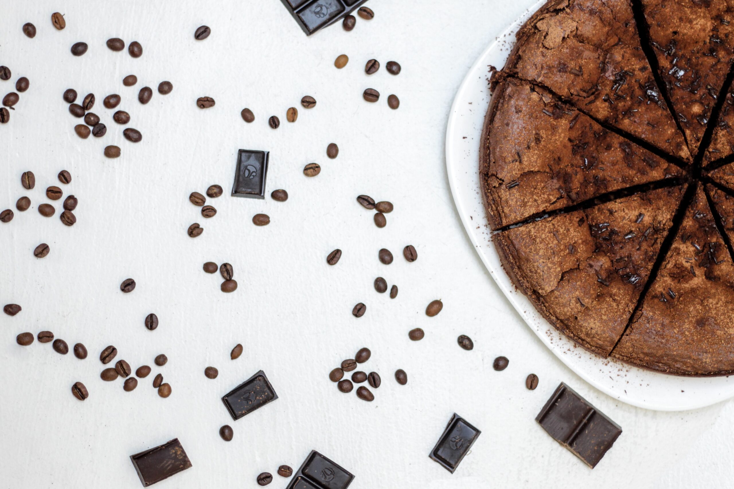 dark chocolate near sliced dark chocolate near sliced chocolate cake and coffee beans