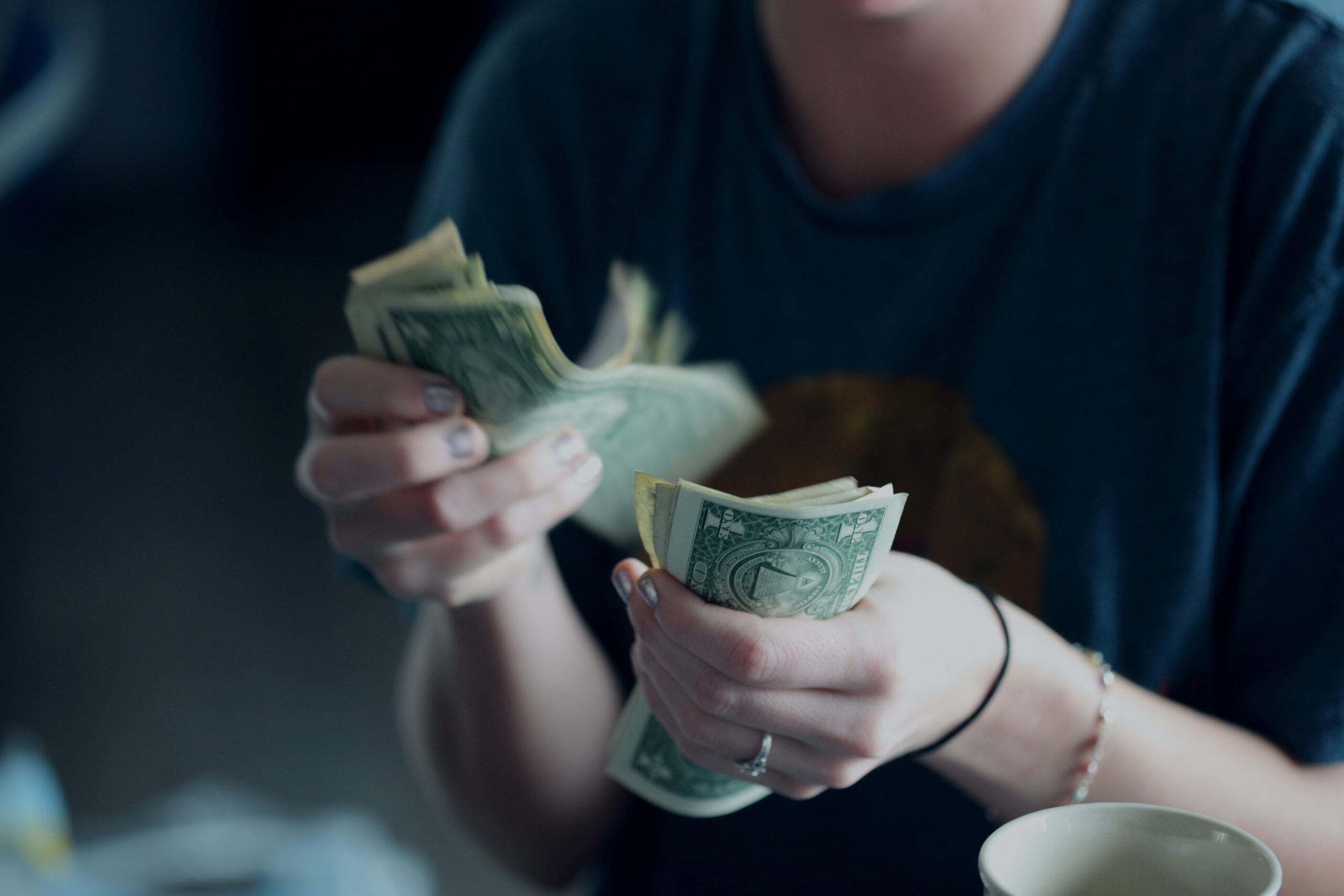 focus photography of person focus photography of person counting dollar banknotes