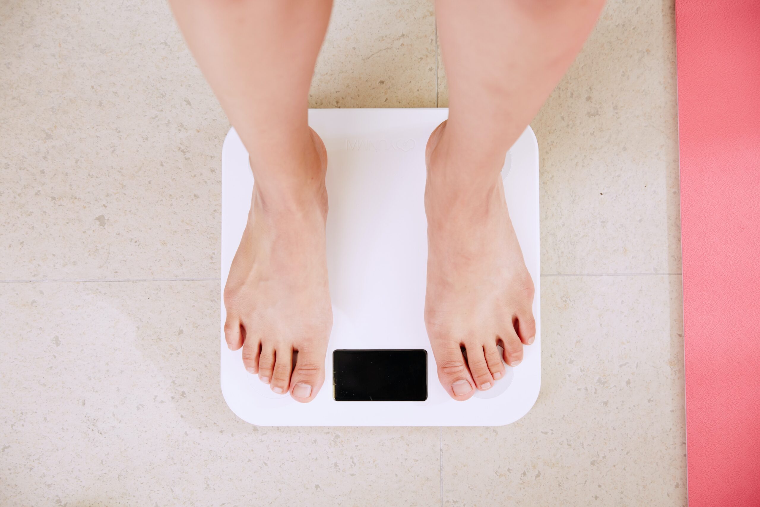 The 18 Best Healthful Foods to Gain Weight Fast person standing on white digital bathroom scale
