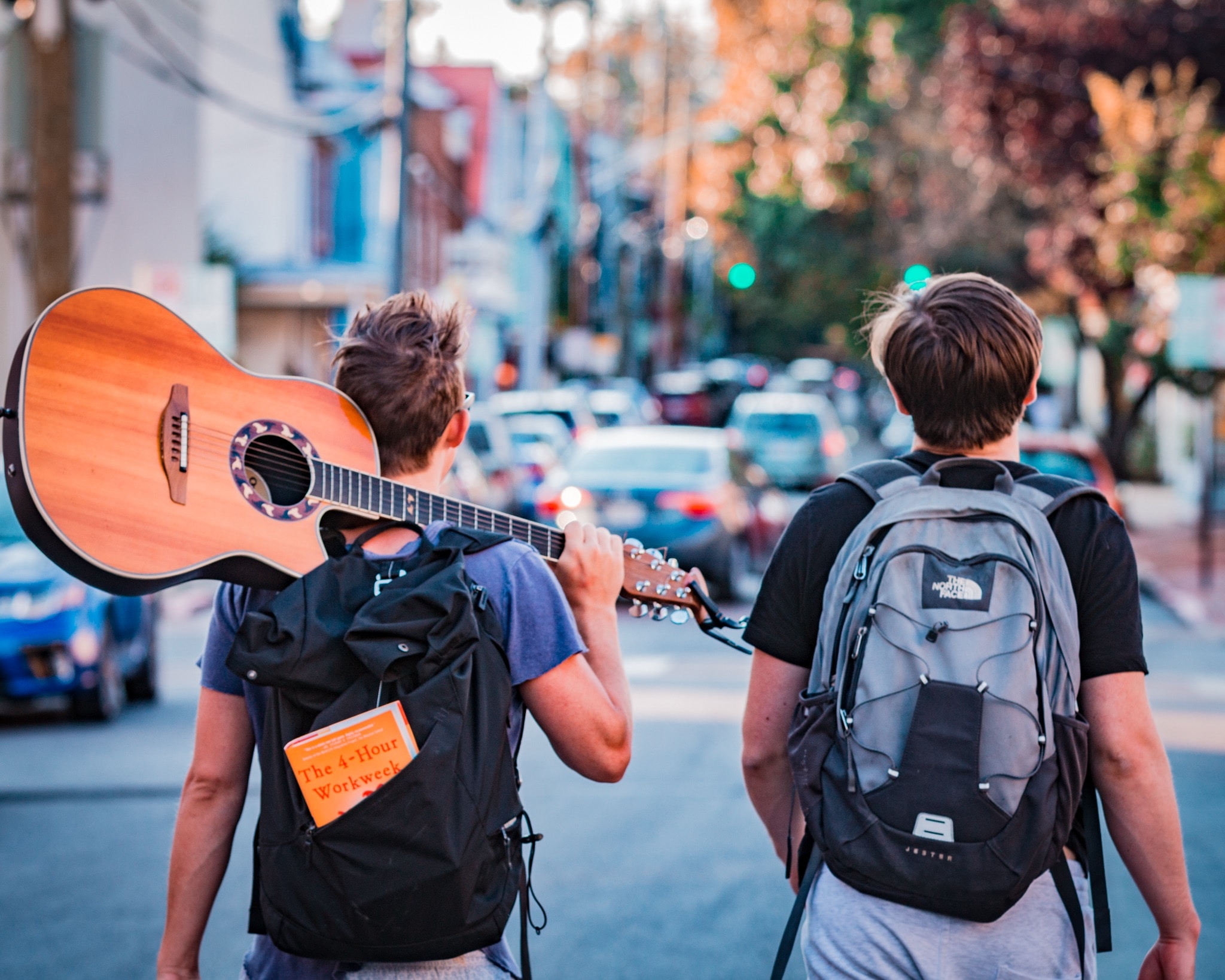 two man carrying backpacks two man carrying backpacks during daytime