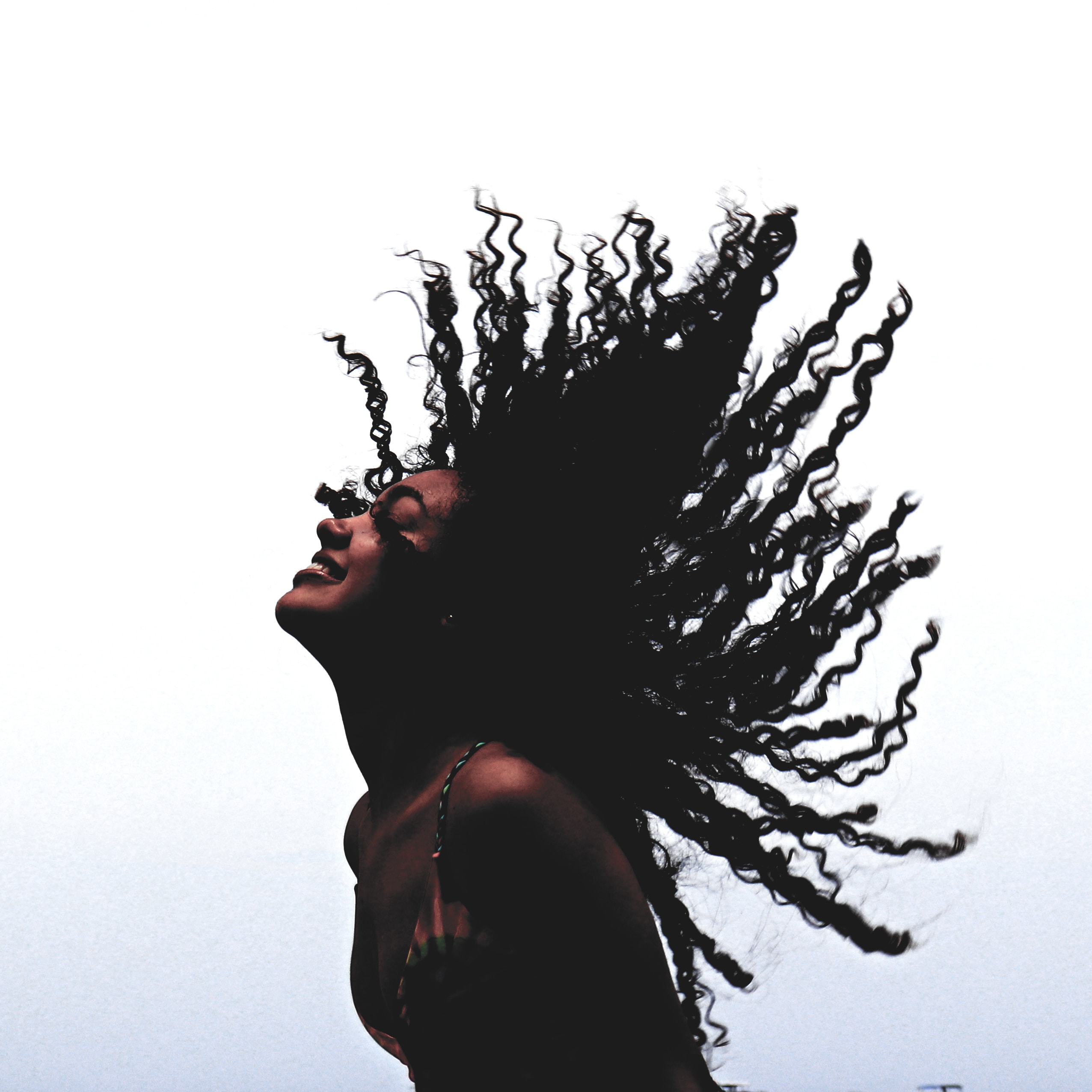woman in black tank woman in black tank top standing beside leafless tree during daytime