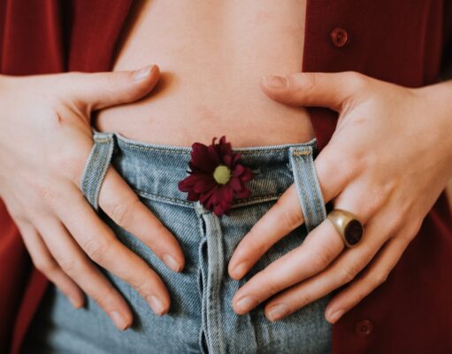 Home Remedies for Gas Pain Crop faceless female in casual clothes decorated with blooming flower revealing bare stomach