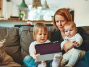 30 Flexible Stay-at-Home Jobs for Moms and Dads to Make Some Extra Cash two babies and woman sitting on sofa while holding baby and watching on tablet